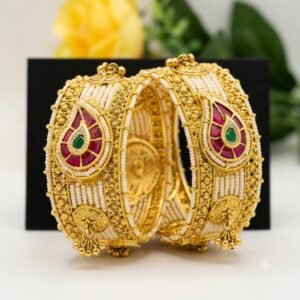 Traditional gold bridal bangles with red and green stones and white pearl detailing